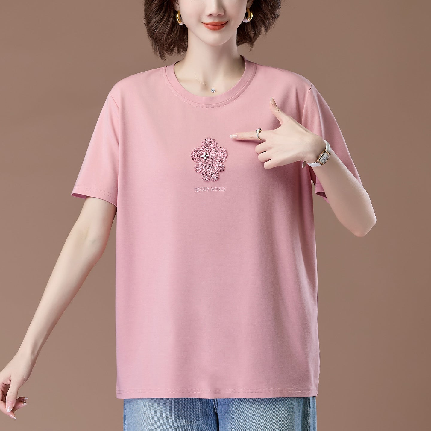 Pink embroidered detail close-up on women's short sleeve t-shirt, Y2K streetwear style | TeenStylo