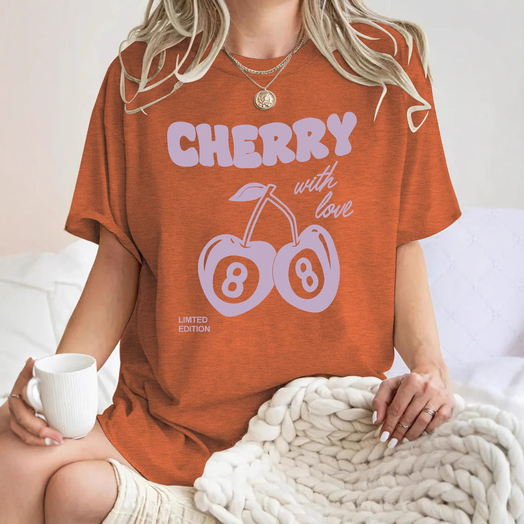 Woman wearing meadow green cherry print short sleeve t-shirt in casual lifestyle setting | TeenStylo
