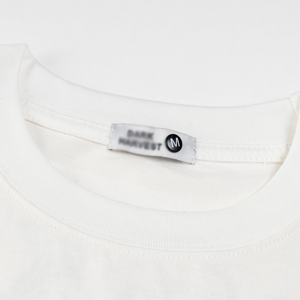 White floral letter embroidery detail on short sleeve shirt, Y2K streetwear style for men | TeenStylo