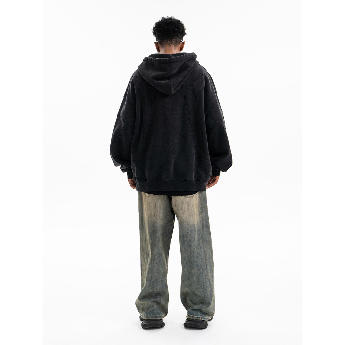 Black oversized patchwork hoodie worn as a streetwear lifestyle look, deconstructed gothic style for men | TeenStylo