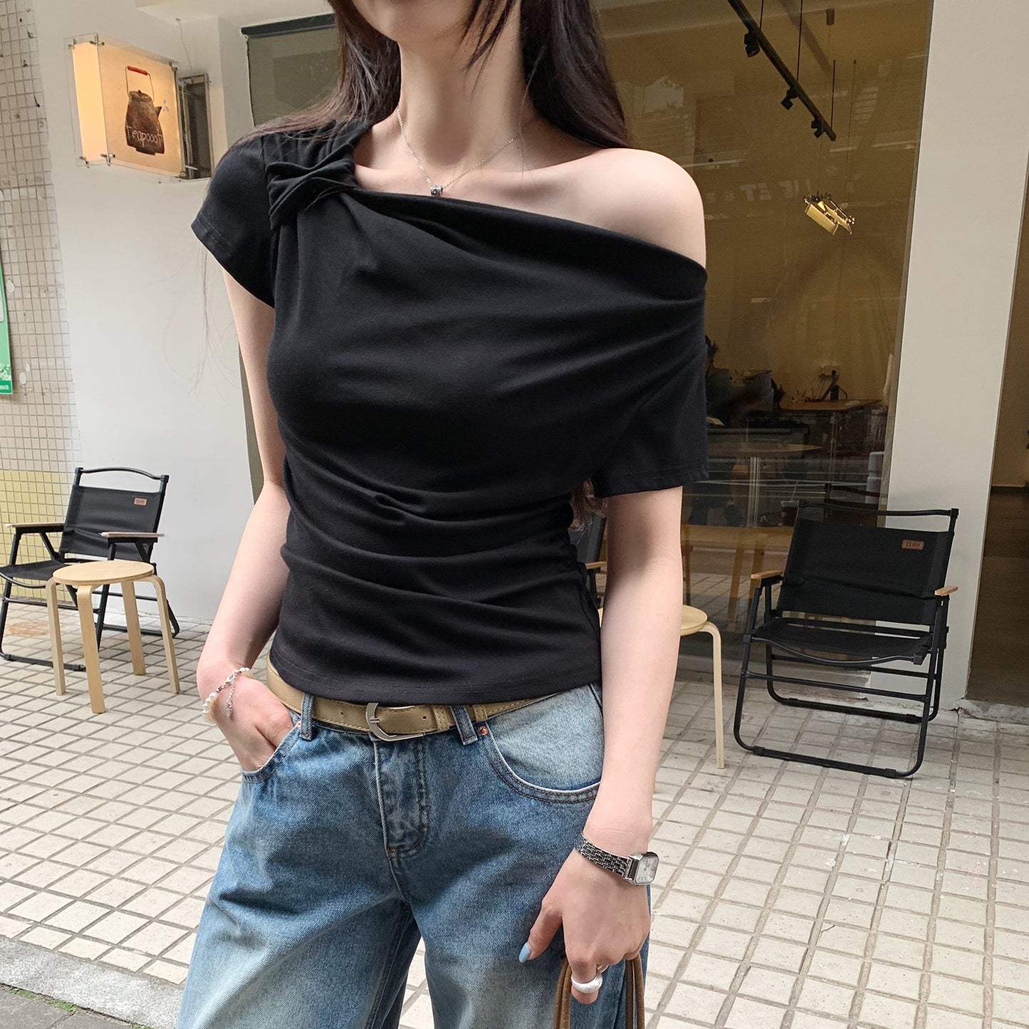Black off-shoulder sleeveless t-shirt styled in a Y2K streetwear lifestyle look for women | TeenStylo