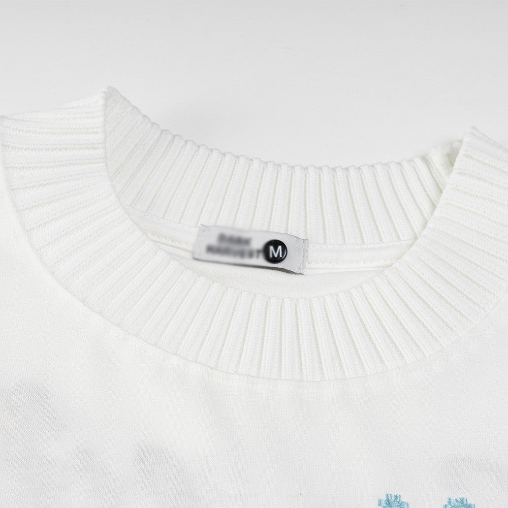 White floral embroidery detail on letter shorts close-up, Y2K streetwear style for teen boys | TeenStylo
