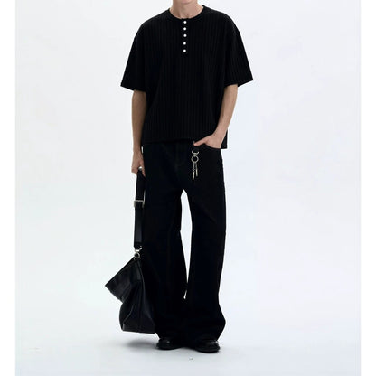 Man wearing black retro knitted henley collar short sleeve t-shirt in casual streetwear lifestyle setting | TeenStylo